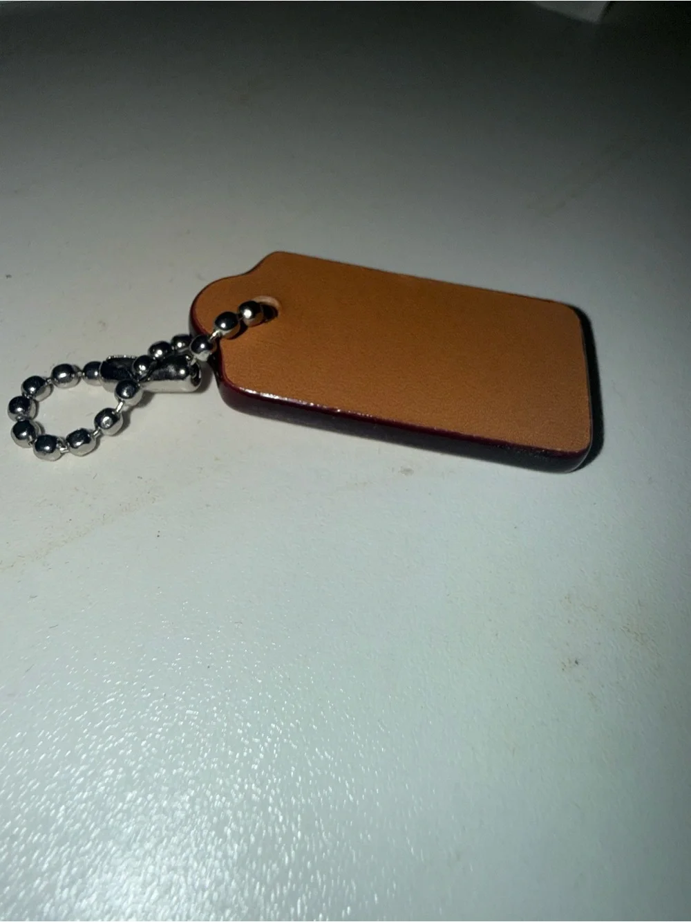 Coach Brown Leather hang Tag from red denim nolita bag